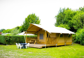 Tienda safari Glamping Deluxe en Holiday Park Duinhoeve, Países Bajos, rodeada de césped y mobiliario exterior.