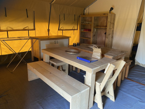 Vue intérieure de la tente Safari XL avec des meubles en bois au Holiday Park Duinhoeve, Pays-Bas.