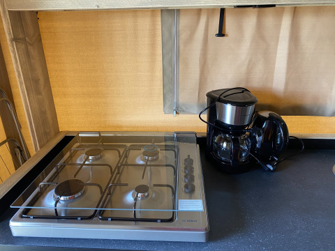 Estufa y cafetera en el área de cocina de Glamping Deluxe tipo 2 en Holiday Park Duinhoeve, Países Bajos.
