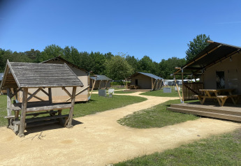 Glamping Deluxe type 2 lodge ved Holiday Park Duinhoeve, Holland, med telte, træborde og natur omgivelser.