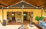 Innenansicht eines luxuriösen Safari-Zeltes auf Camping Vossenberg in den Niederlanden mit Ess- und Loungebereich.