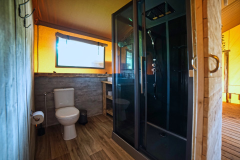 Baño moderno con inodoro y ducha en la Safari tent DeLuxe en Camping Vossenberg, Países Bajos.
