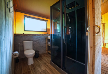 Modernes Badezimmer mit Toilette und Dusche im Safari-Zelt DeLuxe auf Camping Vossenberg, Niederlande.