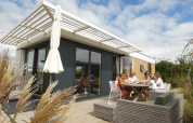 Familia disfruta al aire libre en una moderna Dune Lodge Family en Camping Zonneweelde, Países Bajos.