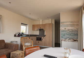 Binnenzicht van de Dune Lodge Family op Camping Zonneweelde in Nederland met moderne keuken en zithoek.