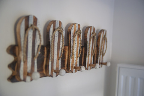 Decoración de pared con percheros en forma de sandalias a rayas en Dune Lodge Family, Camping Zonneweelde.