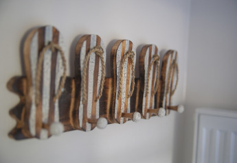 Wanddecoratie met haken in de vorm van gestreepte slippers bij Dune Lodge Family op Camping Zonneweelde.