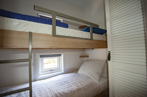 Modern bunk beds in a cozy room at Dune Lodge Family, Camping Zonneweelde, Netherlands, minimalist style.