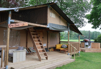 Tenda safari Ranger DeLuxe con vasca idromassaggio e terrazza in legno al Camping Vossenberg, Paesi Bassi.
