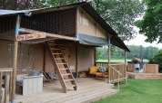 Tente safari Ranger DeLuxe avec jacuzzi et terrasse en bois au Camping Vossenberg, Pays-Bas, en pleine nature.
