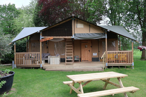 Tienda safari Ranger DeLuxe con jacuzzi en Camping Vossenberg, Países Bajos, con terraza de madera.