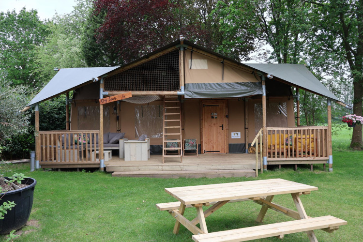 Tienda safari Ranger DeLuxe con jacuzzi en Camping Vossenberg, Países Bajos, con terraza de madera.