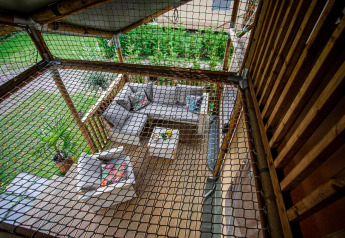 Top view of a covered terrace with modern garden furniture and safety net at Camping Vossenberg, Netherlands.