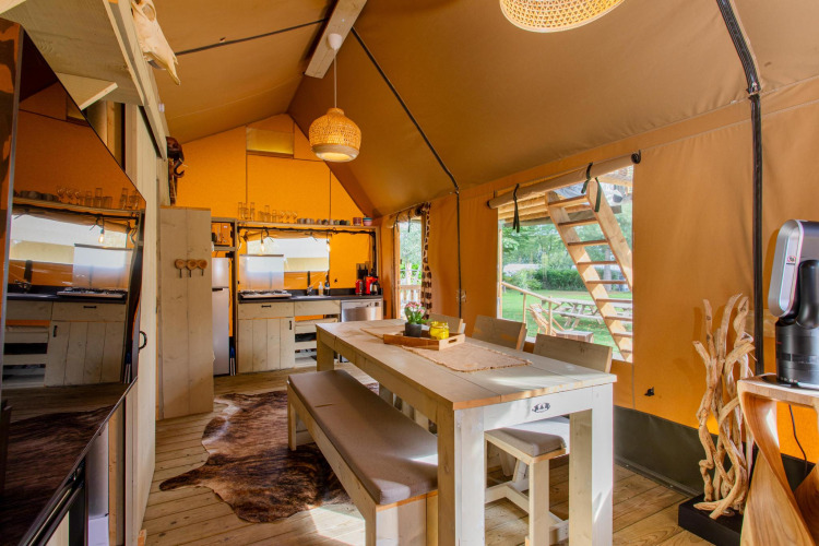 Interieur van Safari tent Ranger DeLuxe met eethoek en keuken op Camping Vossenberg in Nederland.
