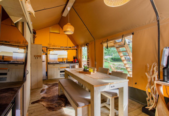 Binnenkant van safari tent Ranger DeLuxe met eetruimte en keuken bij Camping Vossenberg, Nederland.