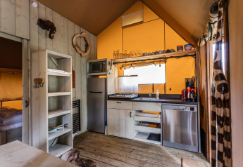 Vista interna della tenda Safari Ranger DeLuxe con cucina e zona notte al Camping Vossenberg, Paesi Bassi.