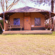 Tenda safari Cottage Kaa presso Camping Vossenberg nei Paesi Bassi con veranda in legno e tavolo da picnic.