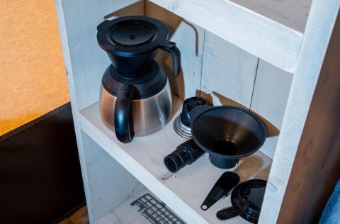 Cafetera y accesorios en un estante blanco en Safari tent Cottage Kaa en Camping Vossenberg, Países Bajos.