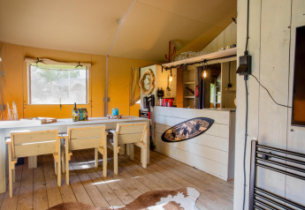 Interior of Safari tent Cottage Kaa at Camping Vossenberg in the Netherlands, rustic decor and wood furniture.