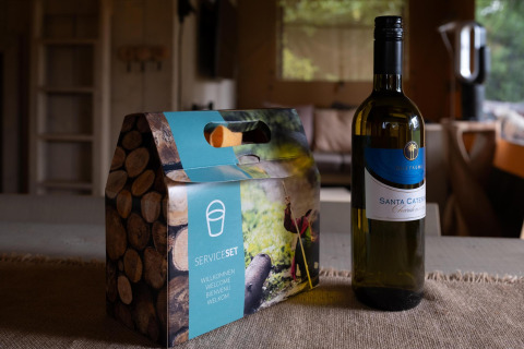 Bouteille de vin et set de service sur la table du Safari tent Cottage Kaa, Camping Vossenberg, Pays-Bas.