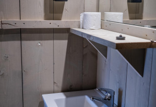 Lavabo y estante con papel higiénico en Safari tent Cottage Kaa en Camping Vossenberg, Países Bajos.