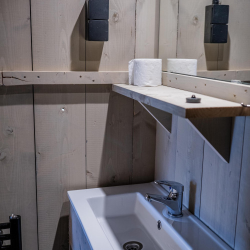 Sink and shelf with toilet paper in Safari tent Cottage Kaa at Camping Vossenberg, Netherlands.