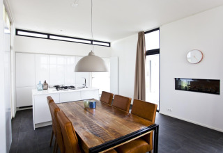 Zona pranzo e cucina moderna nella lodge L-Cube 6 a Schoneveld, Paesi Bassi, con interni eleganti.