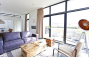 Salon moderne à L-Cube 6 à Schoneveld, Pays-Bas, avec grandes fenêtres et mobilier contemporain.