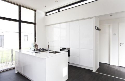 Cucina moderna minimalista nel L-Cube 6 a Schoneveld, Paesi Bassi, con mobili bianchi e ampie finestre.