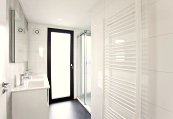 Moderne badeværelsesfaciliteter i L-Cube 6, Schoneveld, Holland med lysindfald og glasbruseniche.