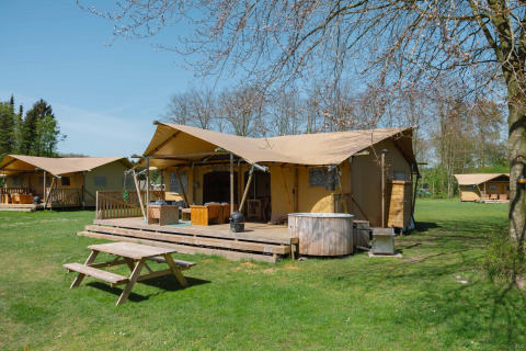 Tienda glamping La Gran Vida en Resort de Parel, Países Bajos, con terraza, mesa y jacuzzi exterior.