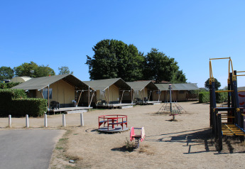 Safaritenten en speeltuin bij recreatiepark en jachthaven Rhederlaagse Meren in Nederland, zonnige dag.