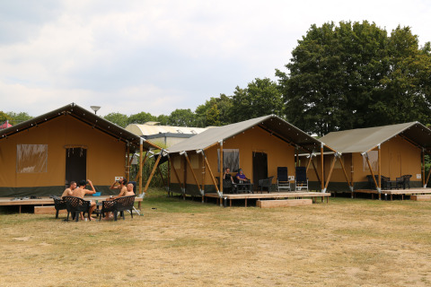 Tentes safari au parc de loisirs et marina Rhederlaagse Meren aux Pays-Bas, des gens se détendent à l’extérieur.