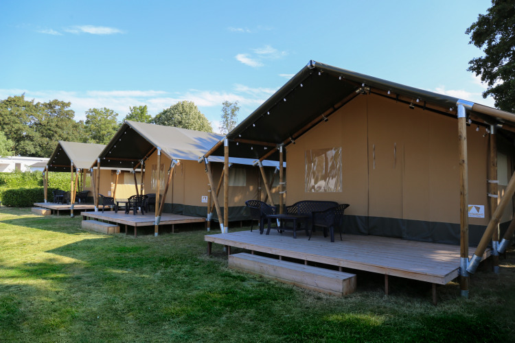 Safari tents on wooden decks at Recreation Park and Marina Rhederlaagse Meren in the Netherlands, sunny day.