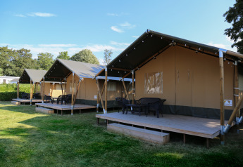 Tentes safari sur terrasses en bois au parc de loisirs Rhederlaagse Meren aux Pays-Bas, journée ensoleillée.