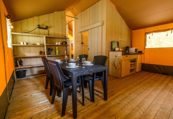 Interior de una tienda safari con mesa de comedor, cocina y estantes en Rhederlaagse Meren, Países Bajos.