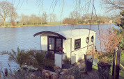 Casa flotante en el parque recreativo y puerto deportivo Rhederlaagse Meren en los Países Bajos, junto al agua.