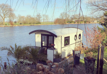 Woonboot aan het recreatiepark en de jachthaven Rhederlaagse Meren in Nederland, omringd door natuur.