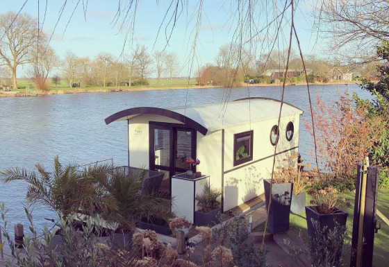 Hausboot am Rhederlaagse Meren Freizeitpark in den Niederlanden, umgeben von Wasser und Natur.