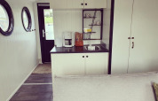 Houseboat kitchen at Rhederlaagse Meren, Netherlands, with coffee maker, sink, and round windows.