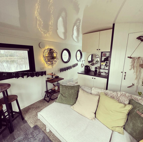 Cozy living area and kitchen inside a houseboat at Marina Rhederlaagse Meren, Netherlands, with soft pillows.