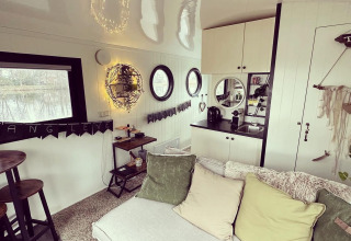 Cozy living area and kitchen inside a houseboat at Marina Rhederlaagse Meren, Netherlands, with soft pillows.
