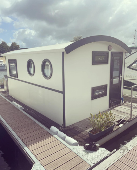Hausboot am Steg im Erholungspark und Jachthafen Rhederlaagse Meren, unter bewölktem Himmel, Niederlande.