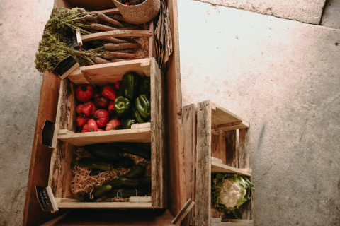 Frisches Gemüse wie Paprika, Karotten und Blumenkohl in Holzkisten auf einem Bauernhof in Hauts-de-France.