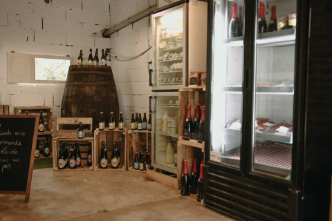 Rustieke winkel met koelkasten, flessen en kratten bij Feather Down Fermette des trois tilleuls, Frankrijk.