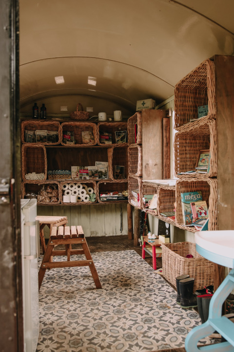 Interno accogliente con scaffali in vimini e provviste alla Fermette des trois tilleuls, Francia.