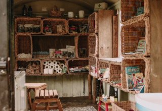 Interno accogliente con scaffali in vimini e provviste alla Fermette des trois tilleuls, Francia.