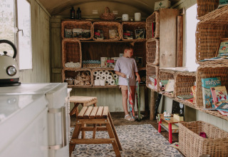 Bambino in una stanza piena di ceste alla Feather Down Fermette des trois tilleuls, Hauts-de-France, Francia.