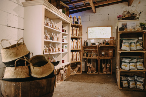 Interior de tienda rural en Feather Down Fermette des trois tilleuls, Hauts-de-France, Francia, con productos locales.