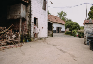 Iemand staat aan de deur van een boerderij bij Feather Down Fermette des trois tilleuls in Hauts-de-France.